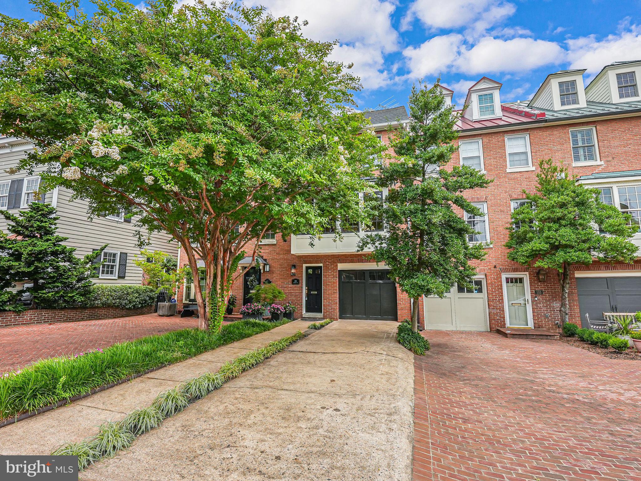 front view of a house with a yard and an trees