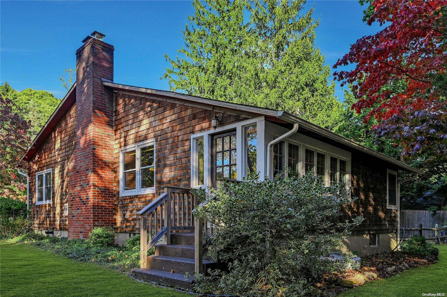 a view of a house with brick walls and a yard with plants