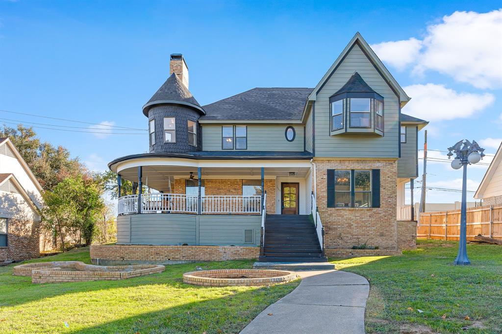 Victorian house featuring a porch and a front yard