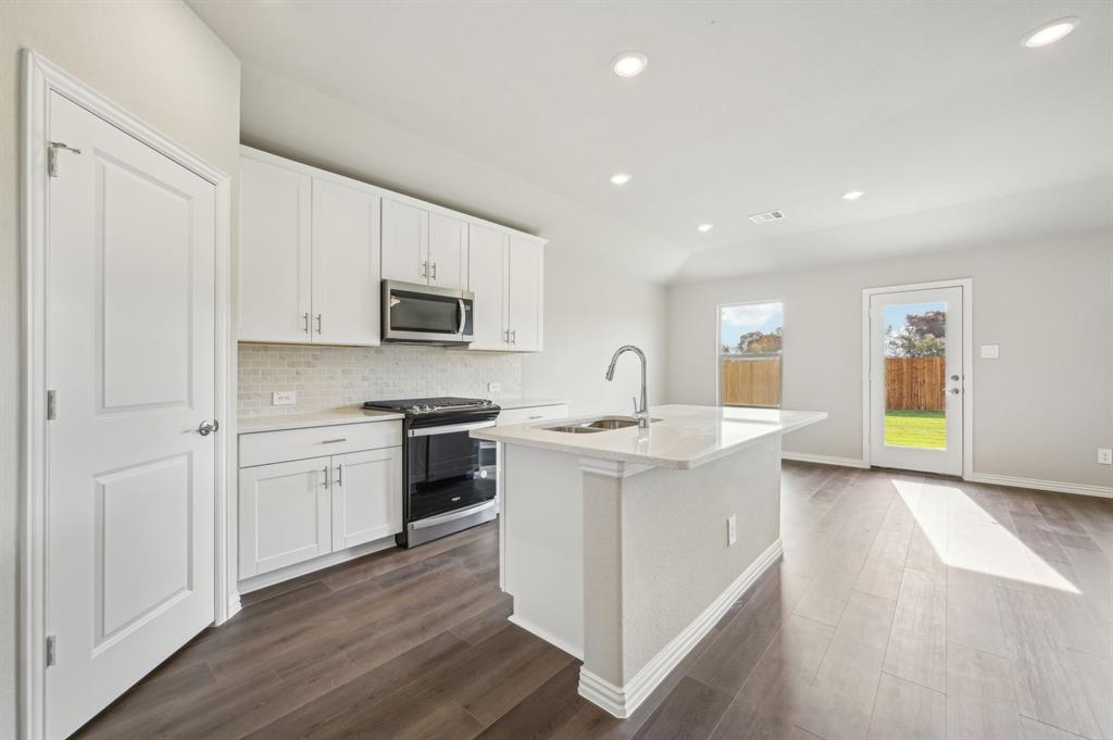 a kitchen with a sink stove and cabinets