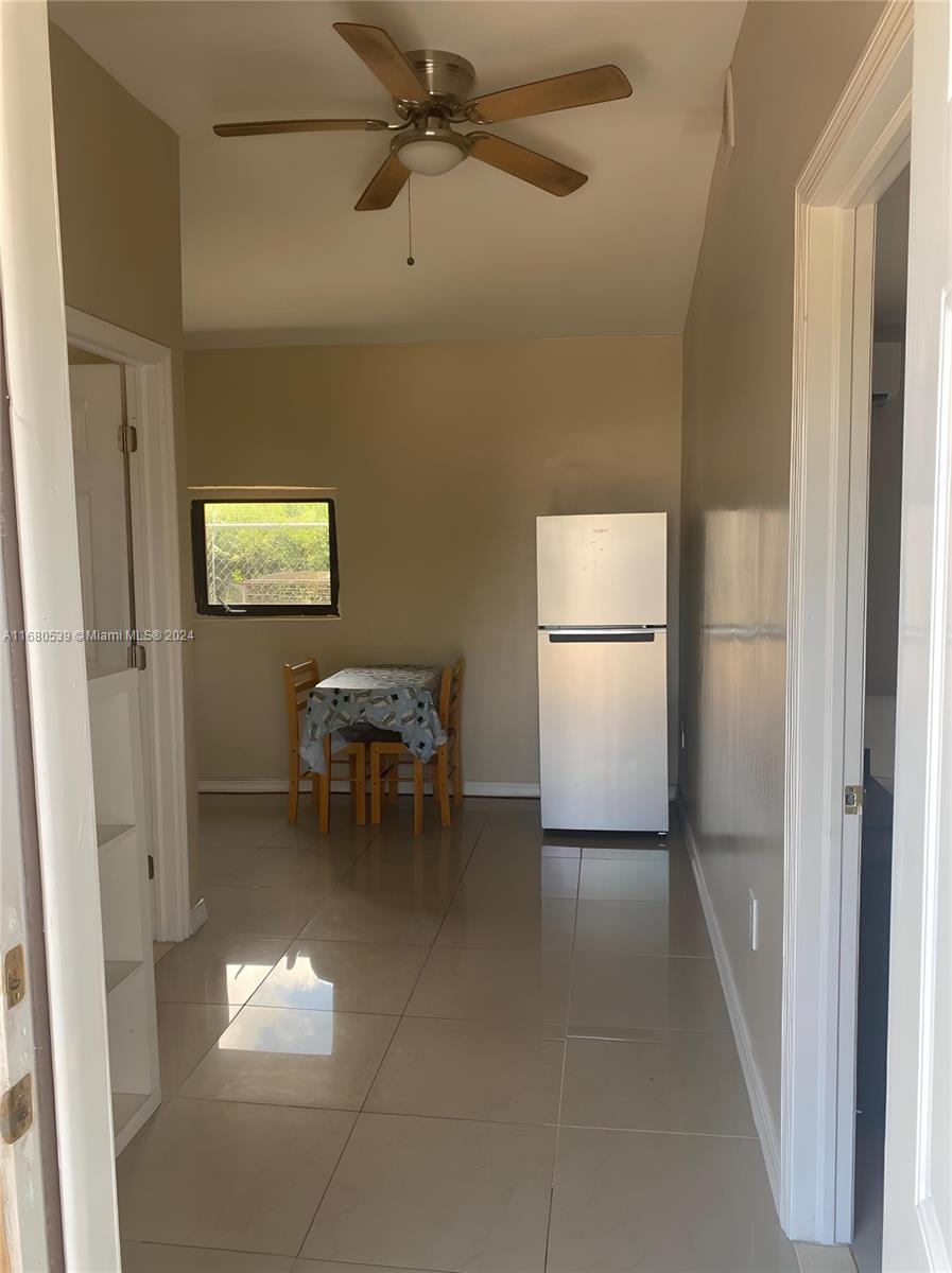 a view of kitchen with a refrigerator and microwave