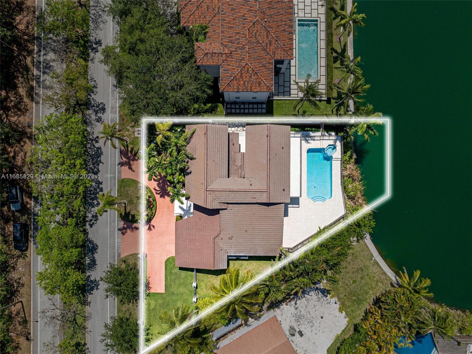 an aerial view of a house with outdoor space lake view and trees all around