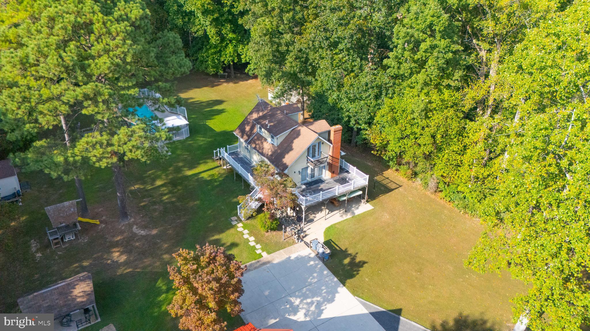 an aerial view of a house with a yard and swimming pool