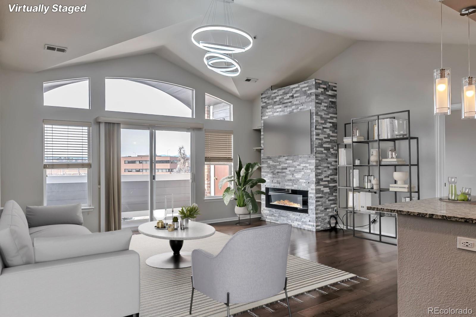 a living room with fireplace furniture and a large window