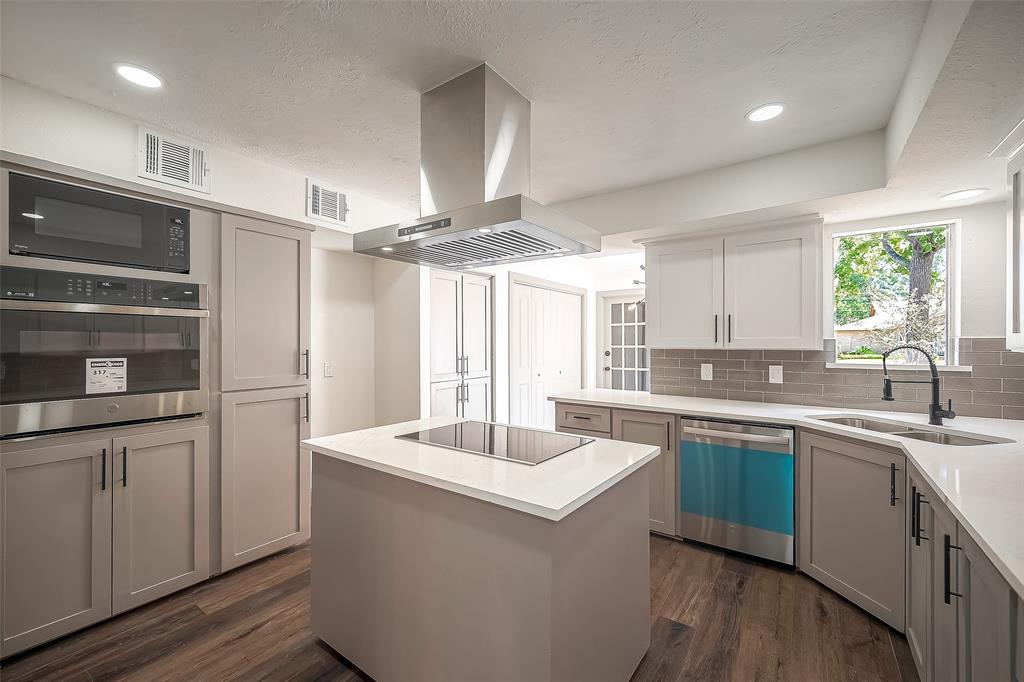 a kitchen with stainless steel appliances a sink stove and cabinets