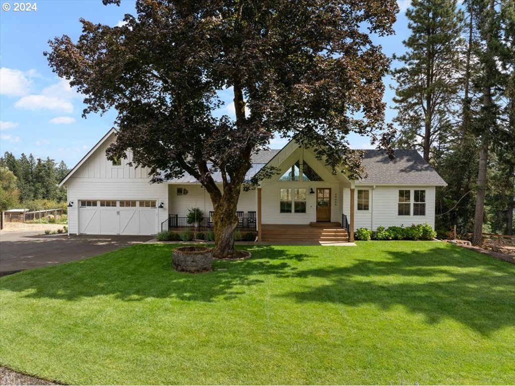 a front view of a house with a garden and trees