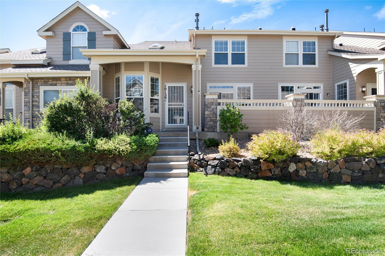 a front view of a house with a yard and flowers