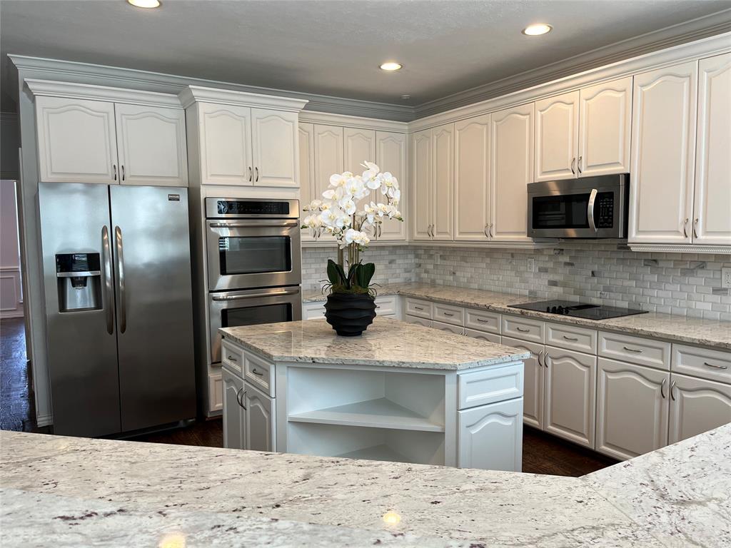 a kitchen with stainless steel appliances kitchen island granite countertop a refrigerator sink and microwave