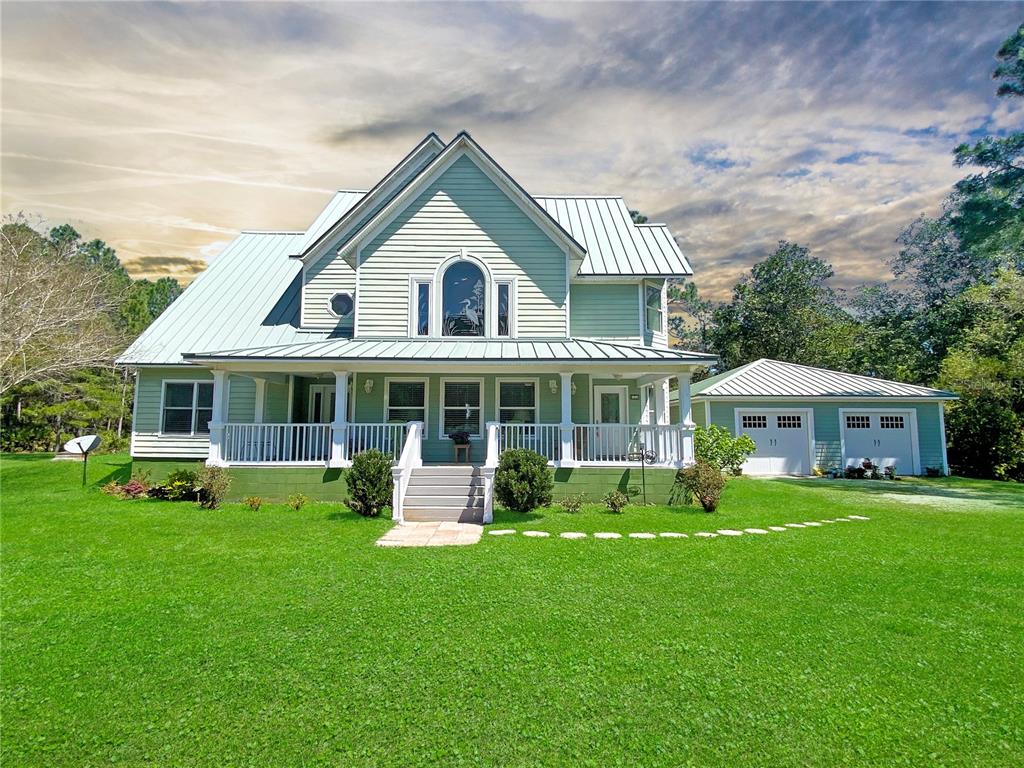 a front view of a house with a yard patio and green space