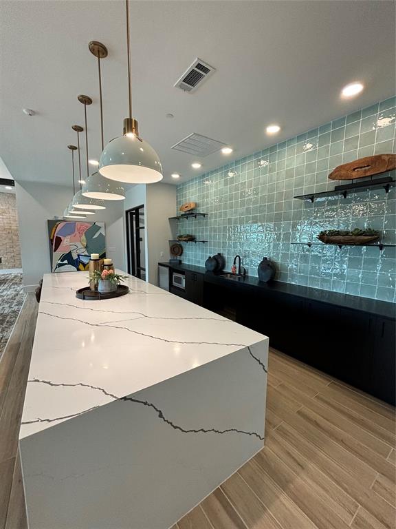 a kitchen with stainless steel appliances kitchen island granite countertop a sink a counter space and cabinets