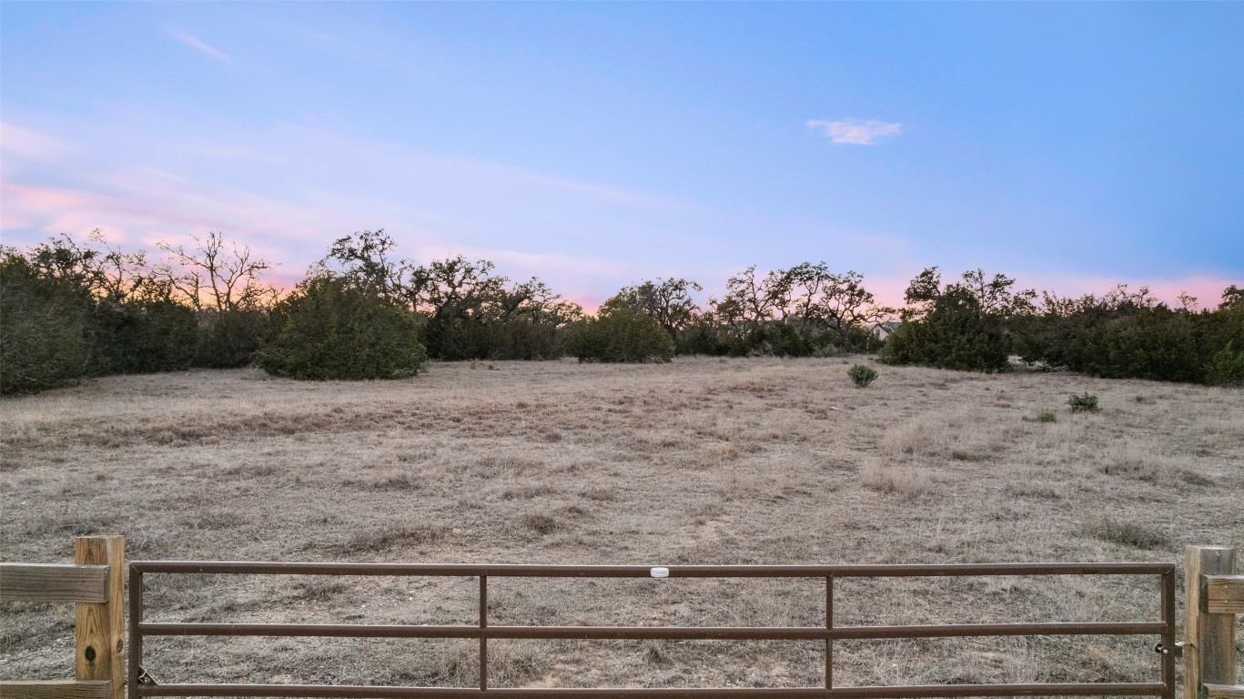 a view of a dry yard with wooden fence