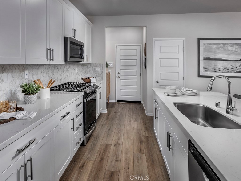 a kitchen with stainless steel appliances a sink stove and cabinets