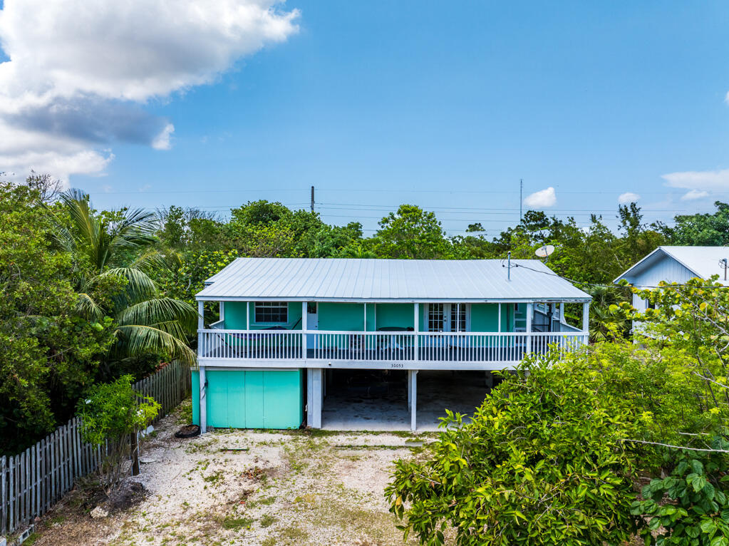 a front view of a house with a yard and potted plants