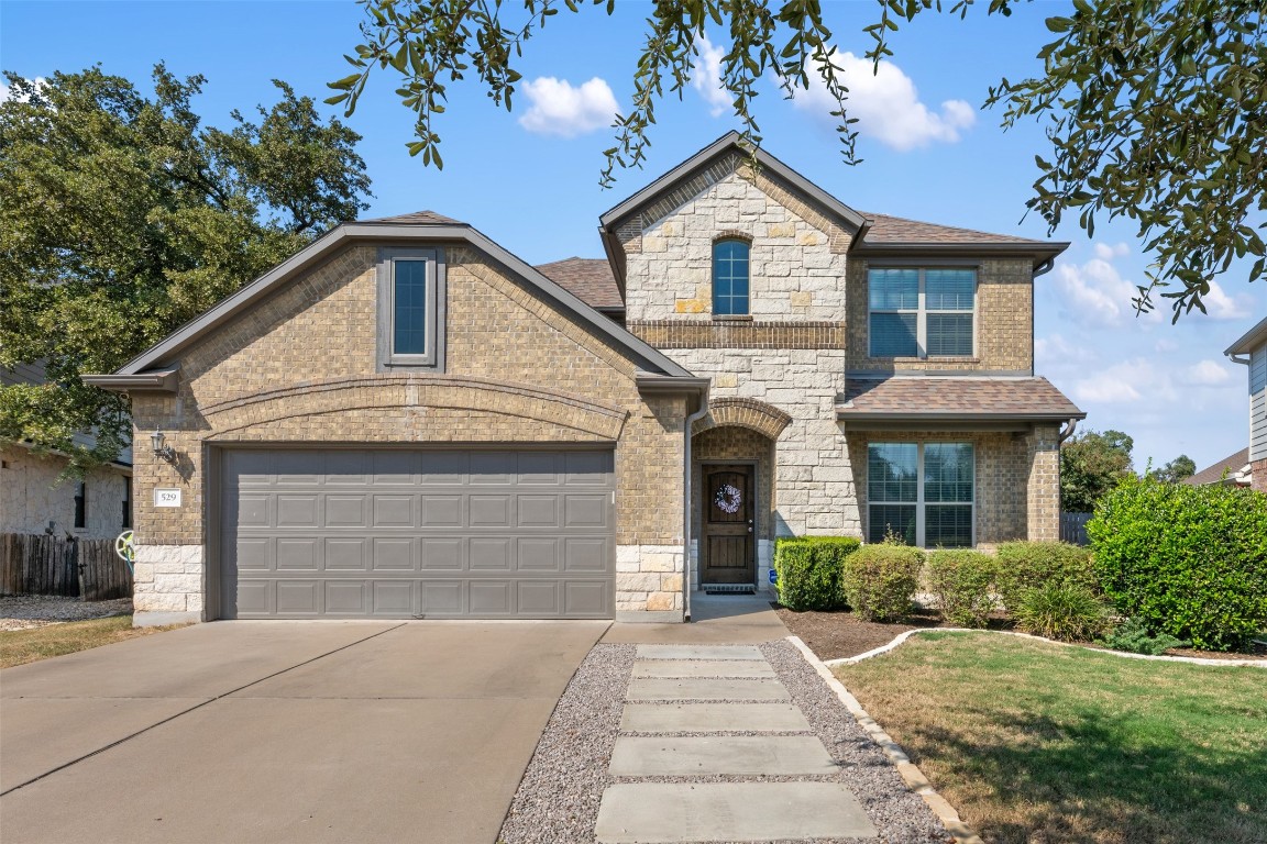 a front view of a house with a yard and garage