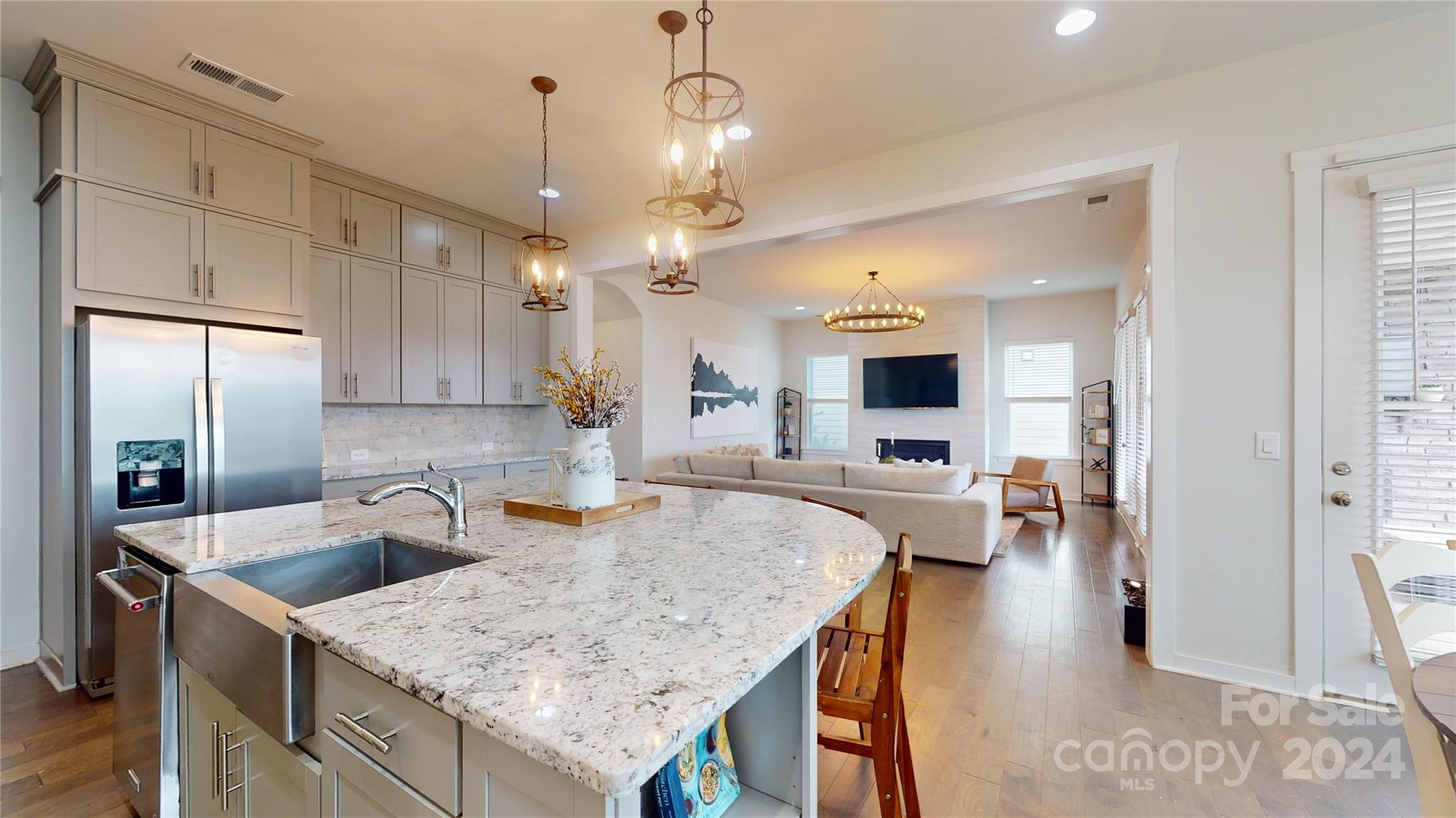 a kitchen with a sink a counter and living room view