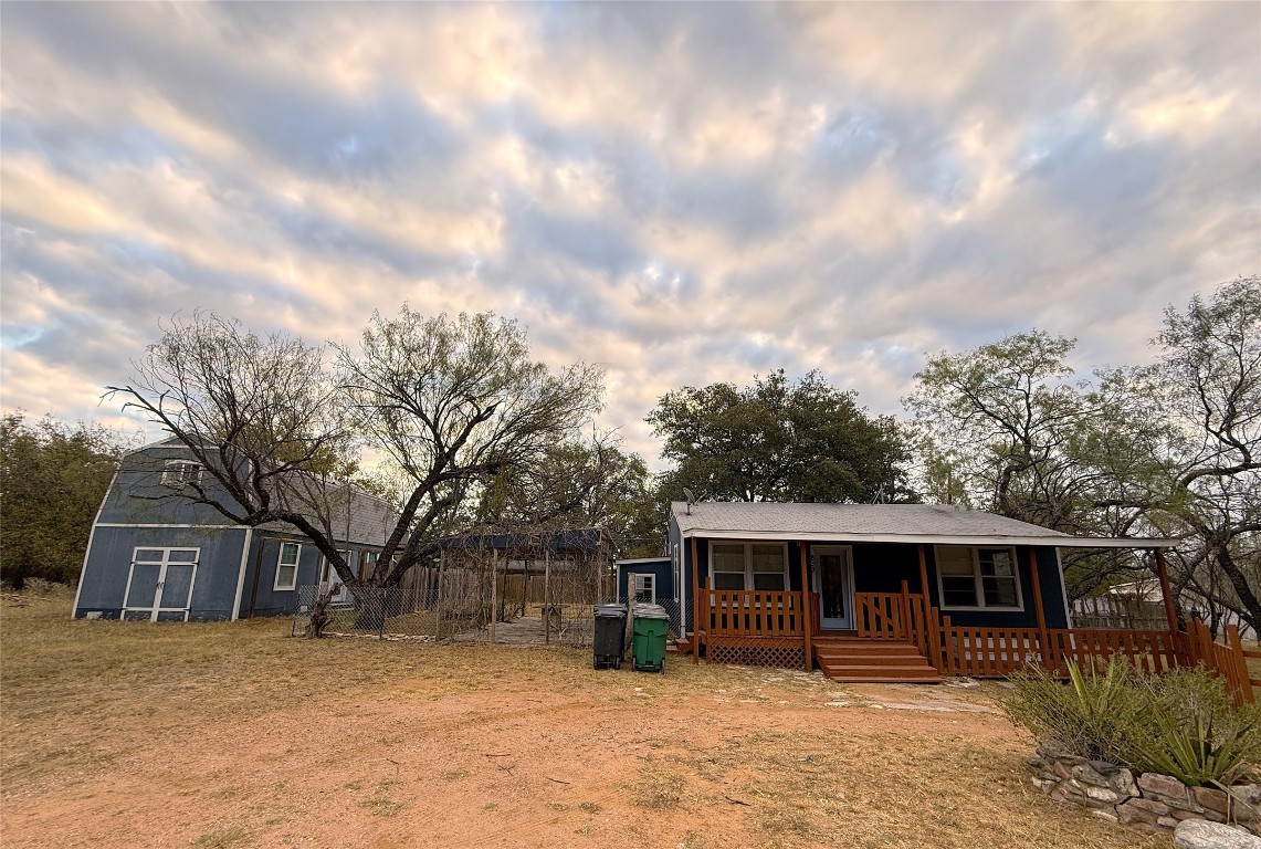 a front view of house with yard and trees in the background