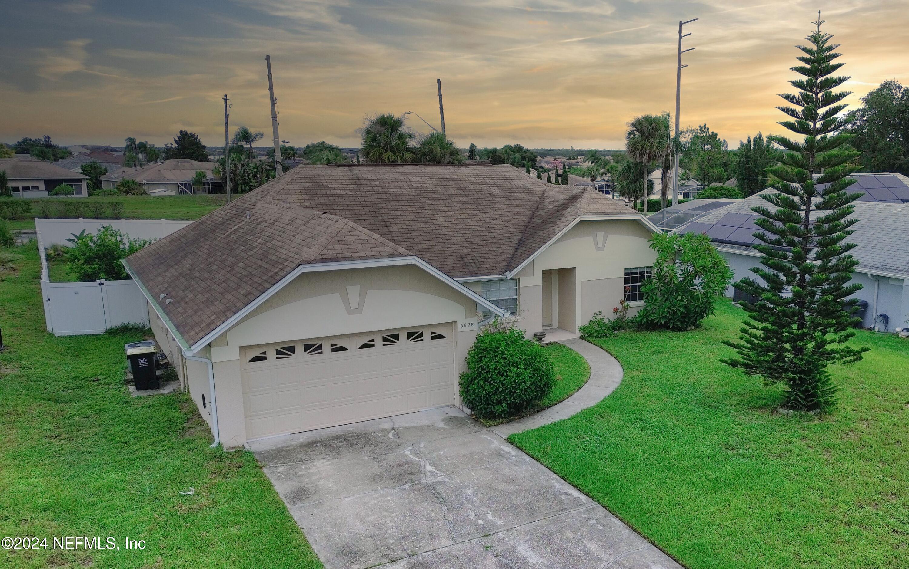 a view of a house with a yard and a fence