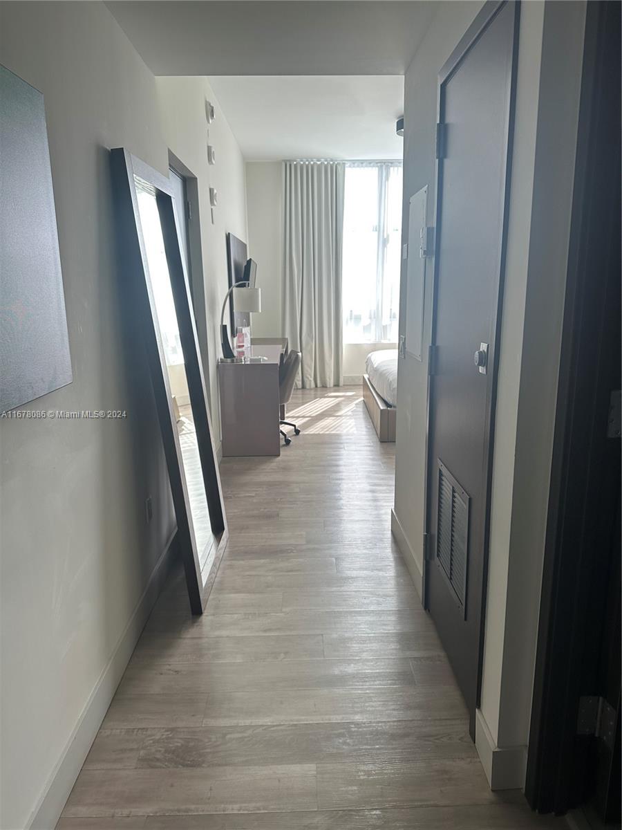 a view of a hallway with wooden floor and stairs