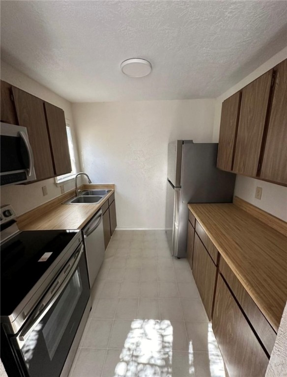 Kitchen featuring a textured ceiling, appliances w