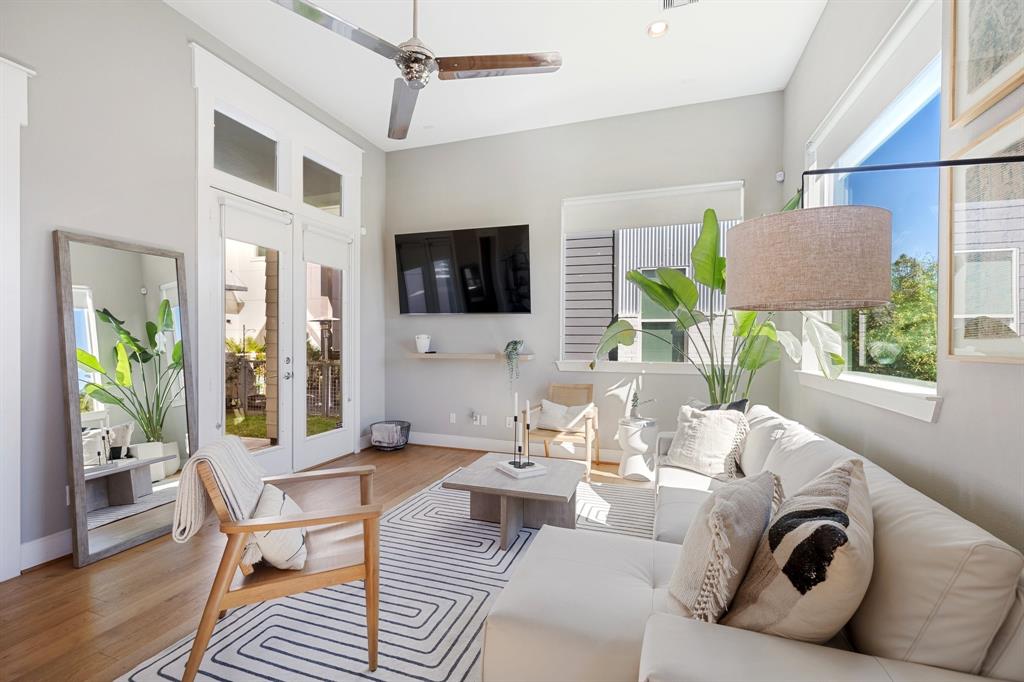 a living room with furniture a flat screen tv and a window