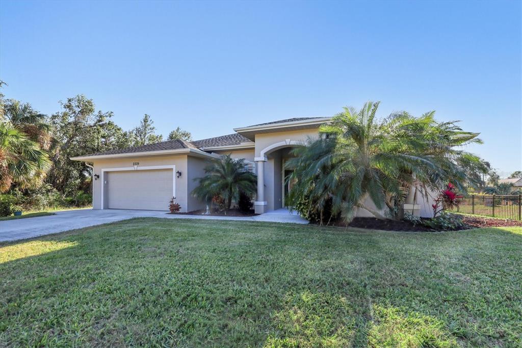 a view of a house with a yard and palm trees