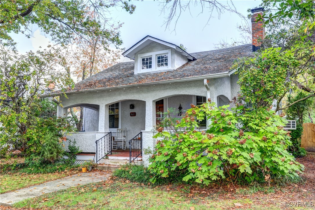 a front view of a house with a garden and trees