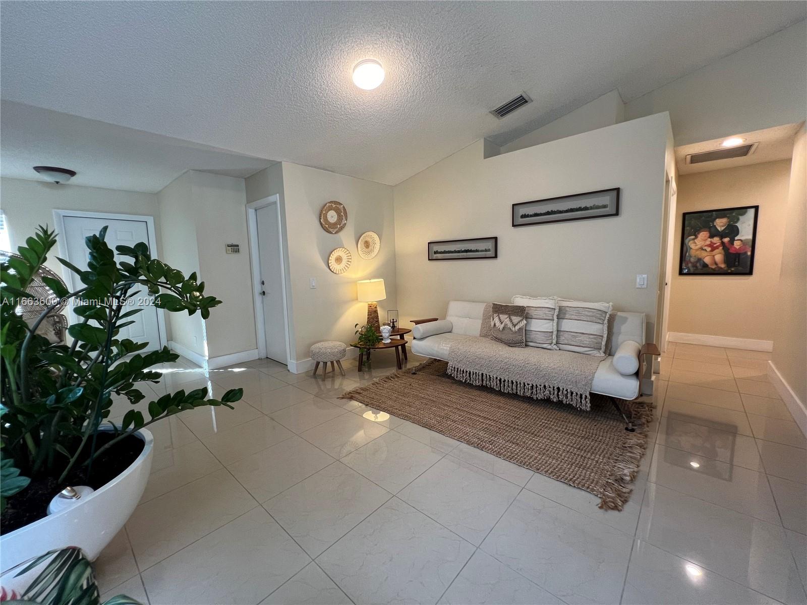 a living room with furniture and a potted plant