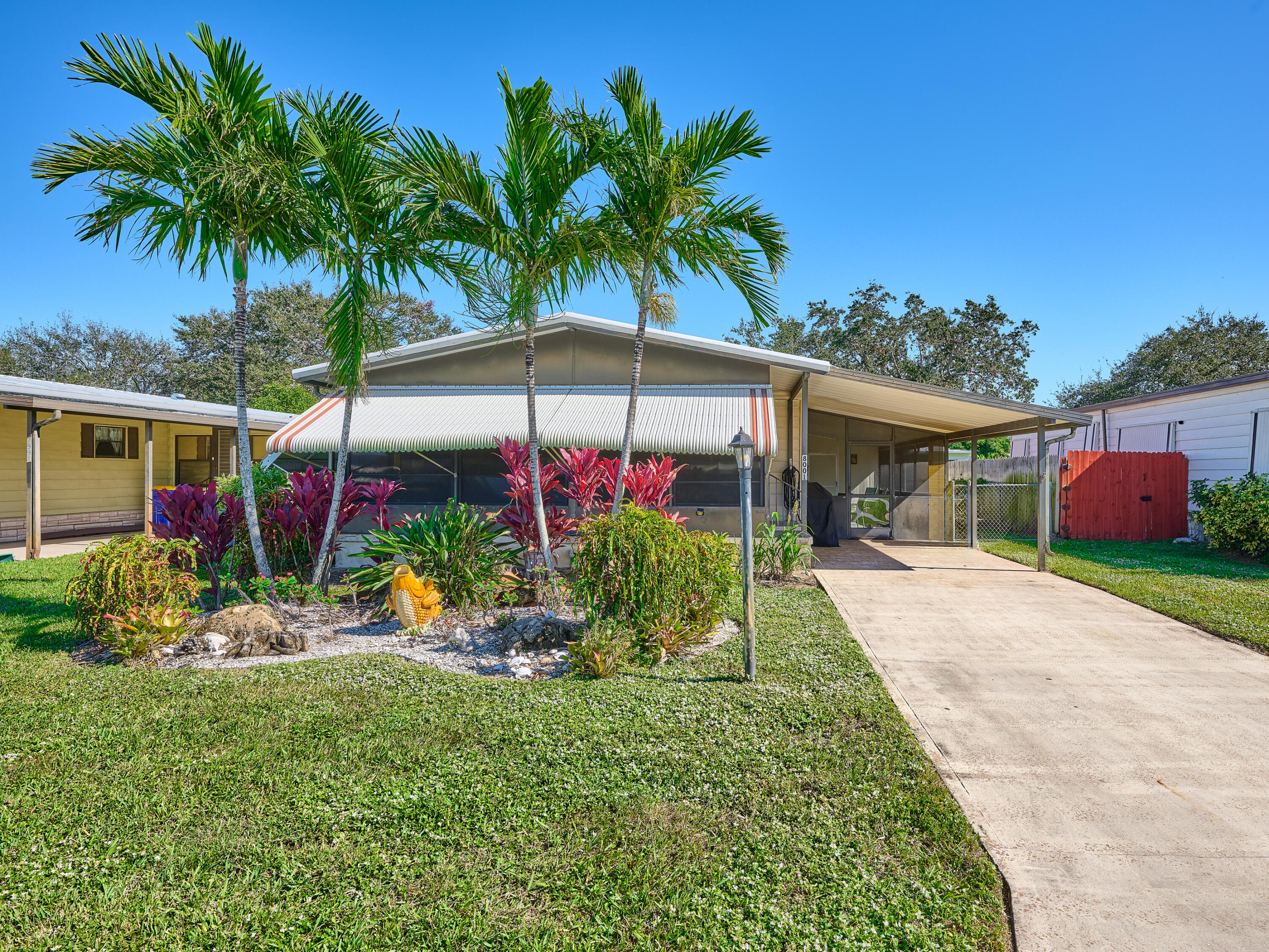 a view of a house with a yard and potted plants