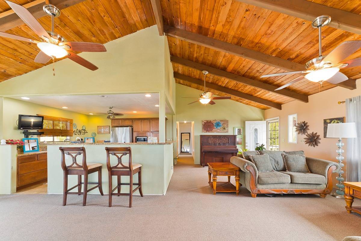 a living room with lots of furniture and kitchen view