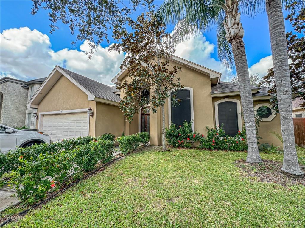 View of front of house with a garage and a front yard