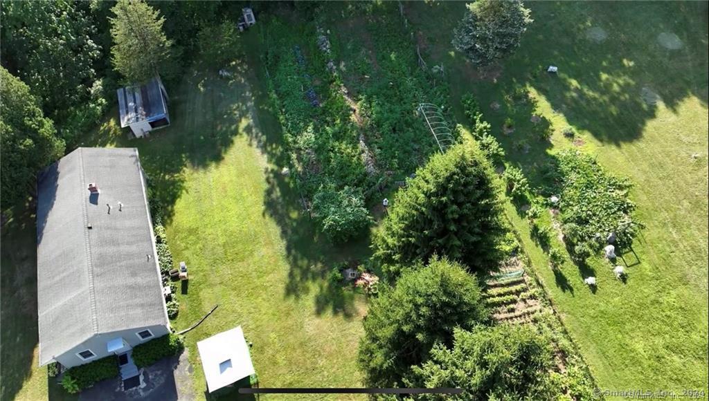 an aerial view of residential house with outdoor space and trees all around