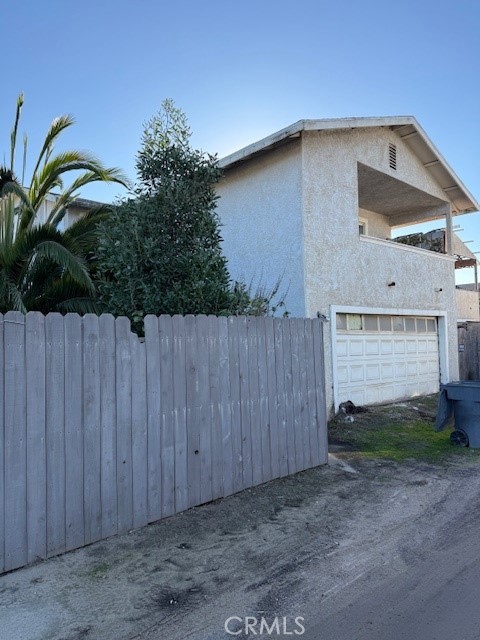 a backyard of a house with potted plants and wooden fence