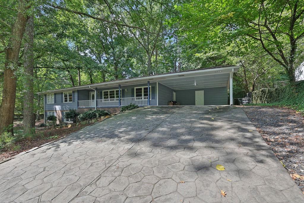 a front view of house with yard and trees around