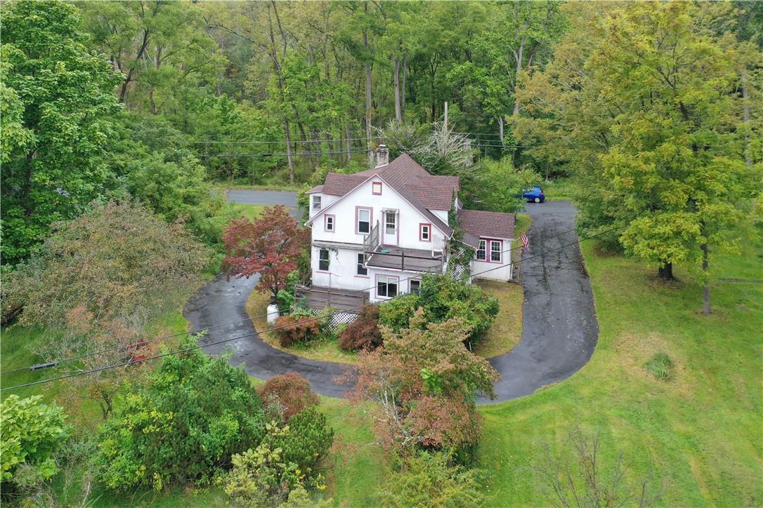 an aerial view of a house with a big yard and large trees