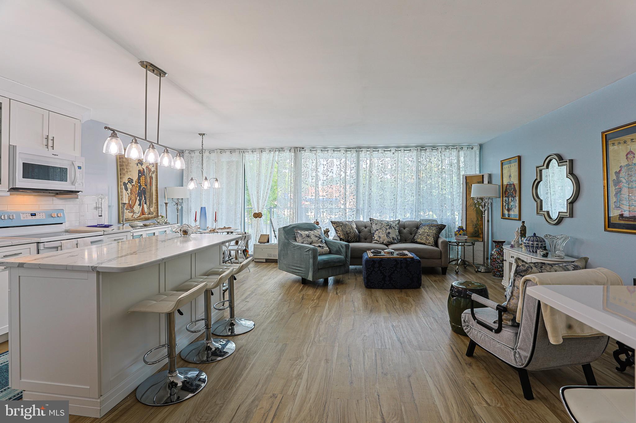 a living room with furniture a flat screen tv and kitchen view