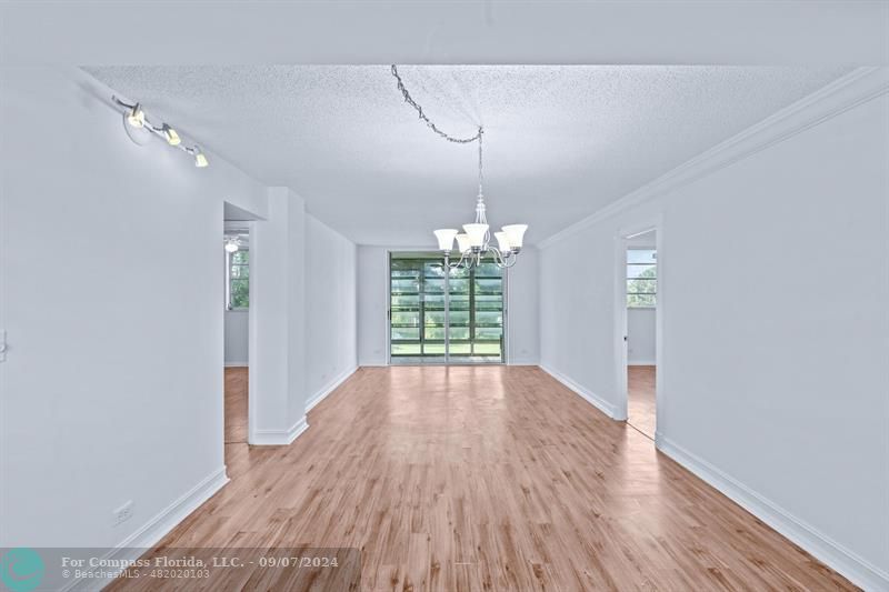 a view of a room with wooden floor chandelier and window