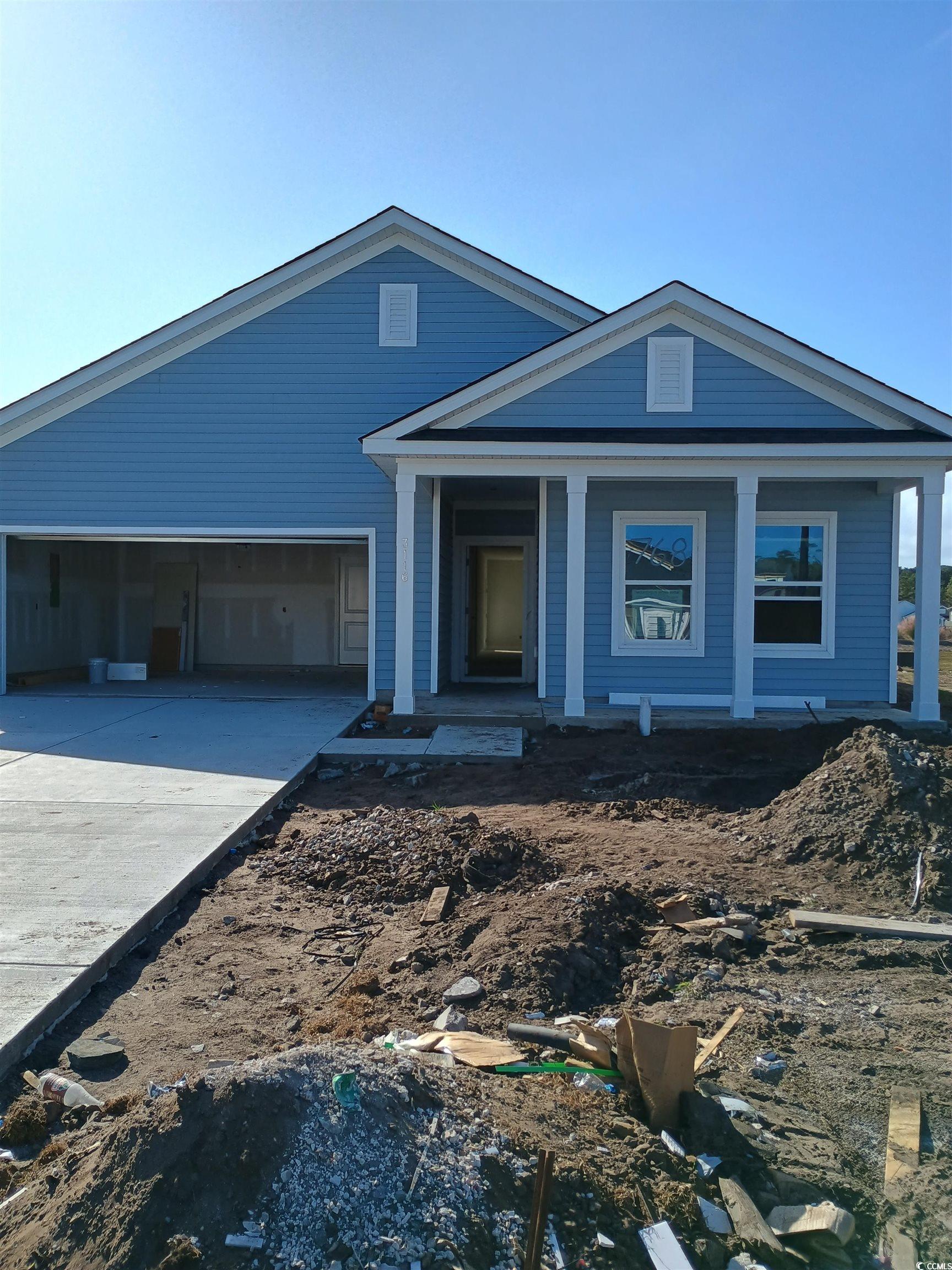 View of front facade with a garage and covered por