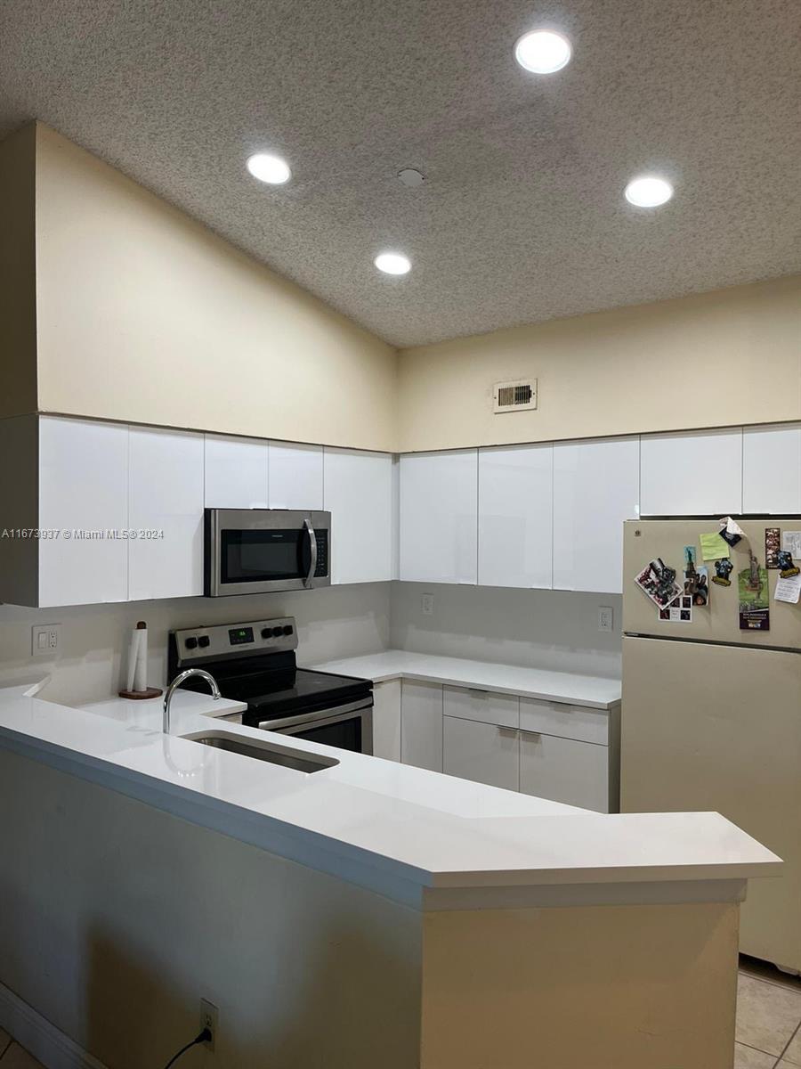 a kitchen with a sink a stove and cabinets