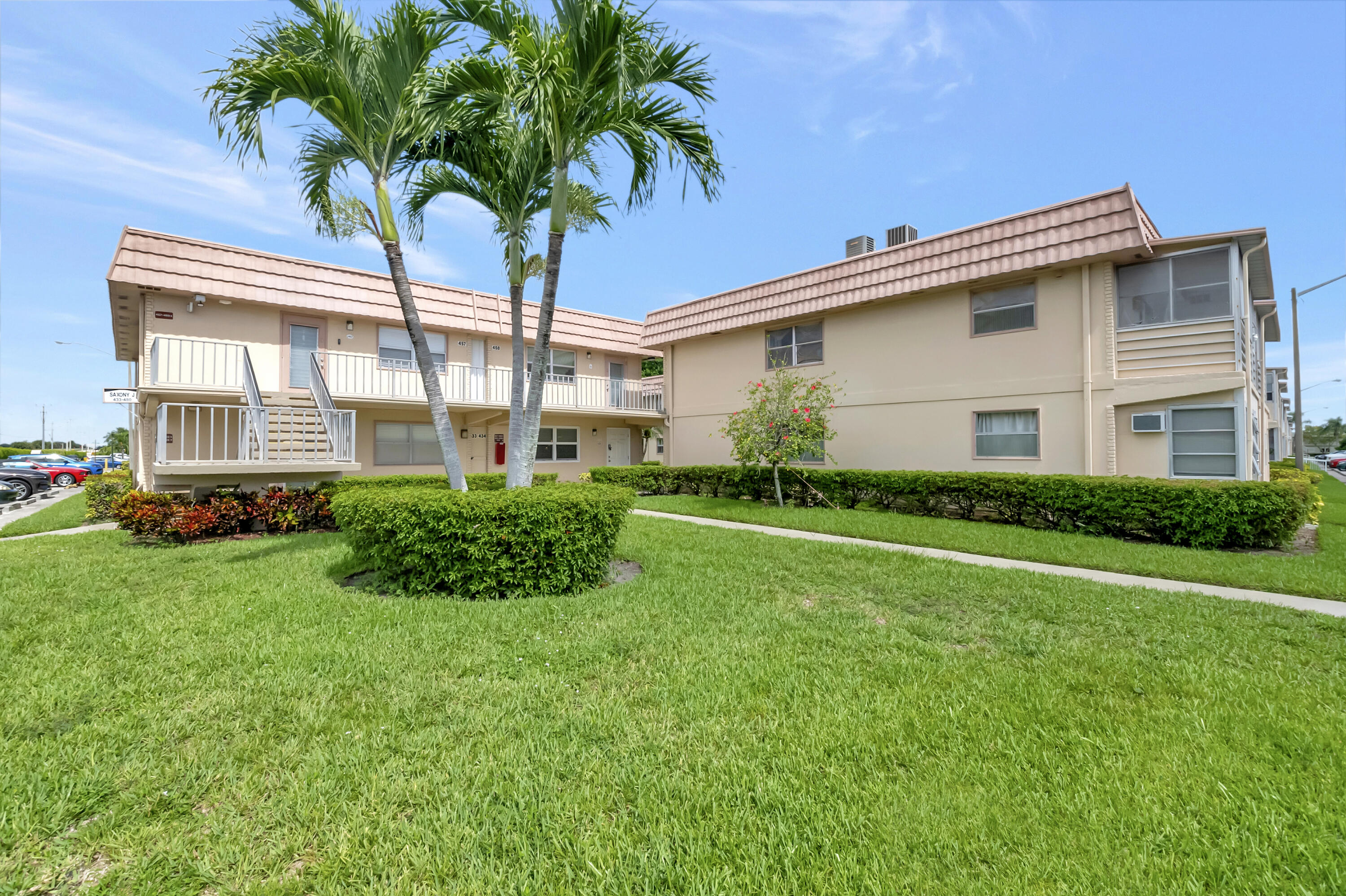 a view of a house with a yard and palm trees