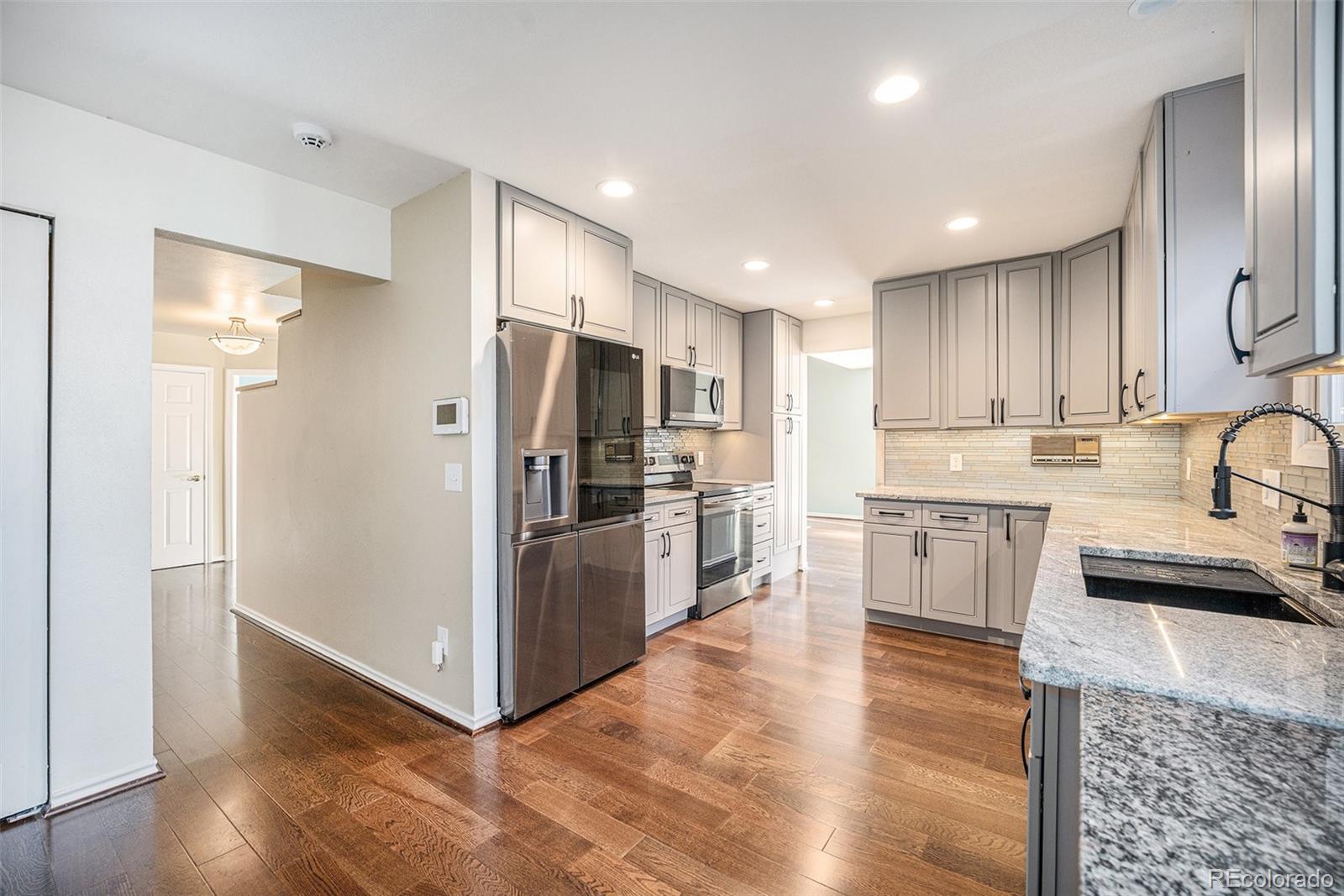 a kitchen with granite countertop a refrigerator and a sink