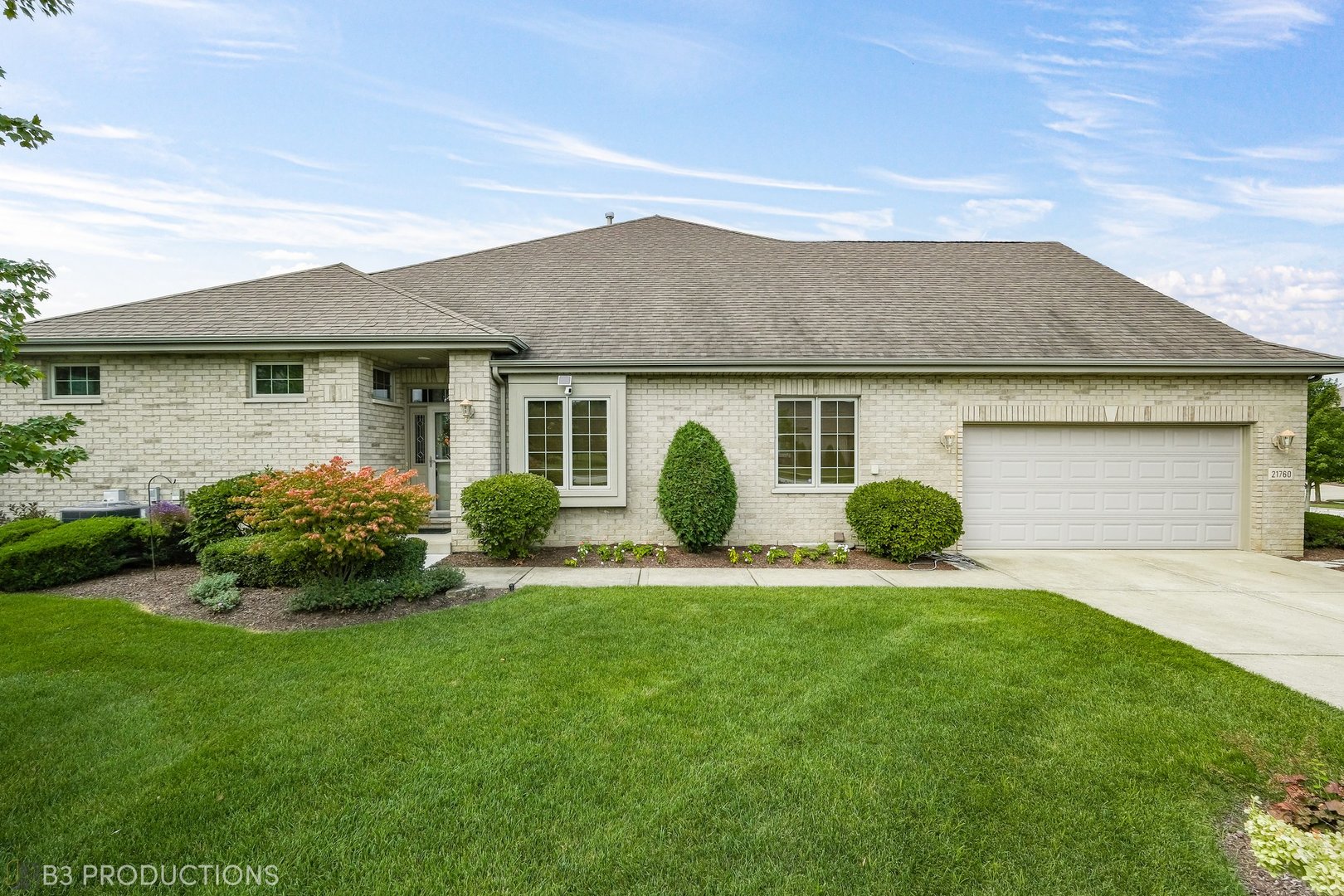 a front view of a house with a garden and yard