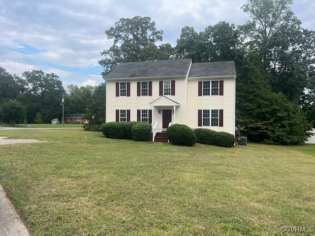 Colonial home featuring a front lawn and central A