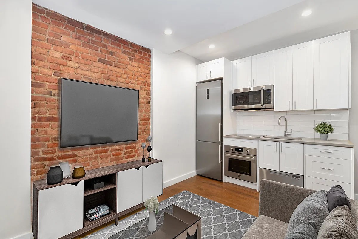 a kitchen with stainless steel appliances a stove microwave and sink