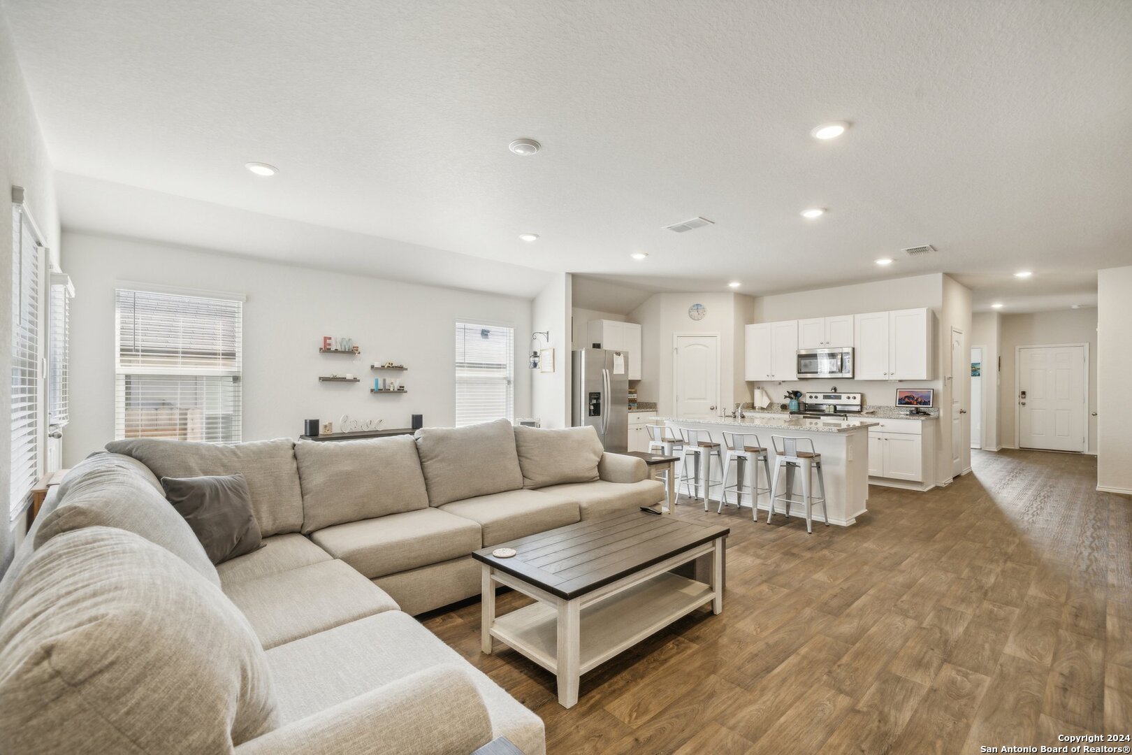 a living room with furniture and view of kitchen