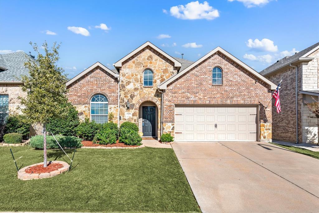 a front view of a house with a yard and garage