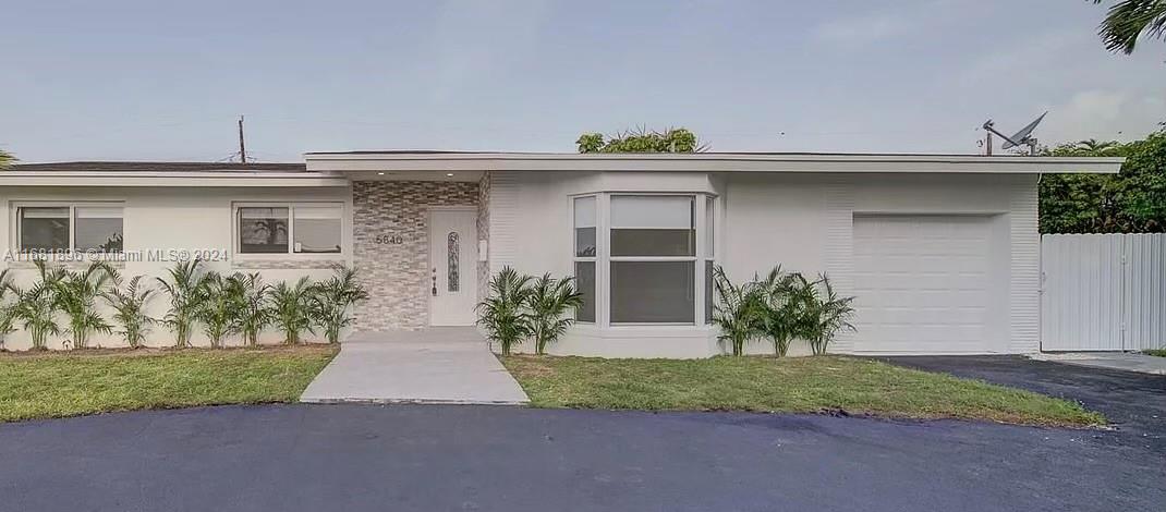 a front view of a house with a yard and a garage