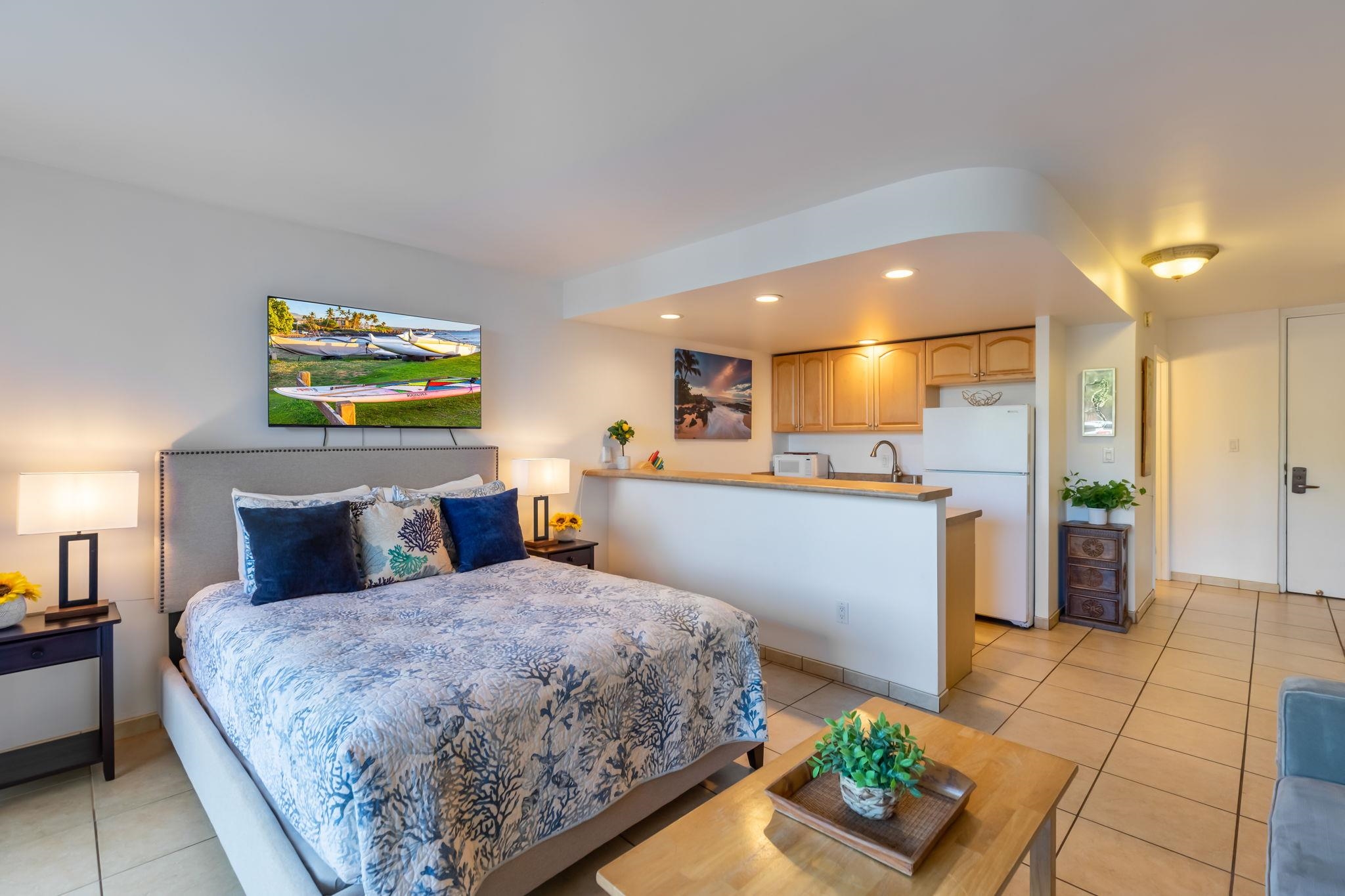 a spacious bedroom with a bed and a view of kitchen