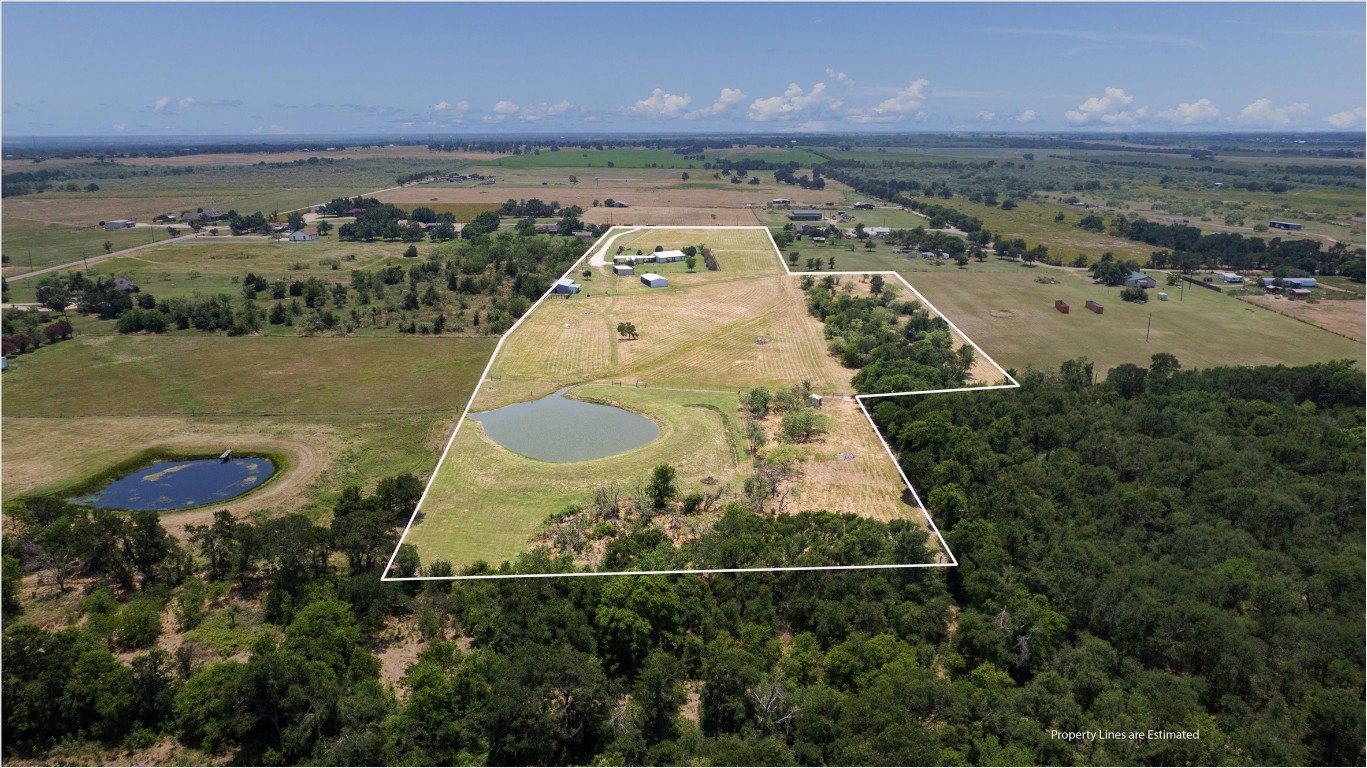 an aerial view of a house with a yard and lake view