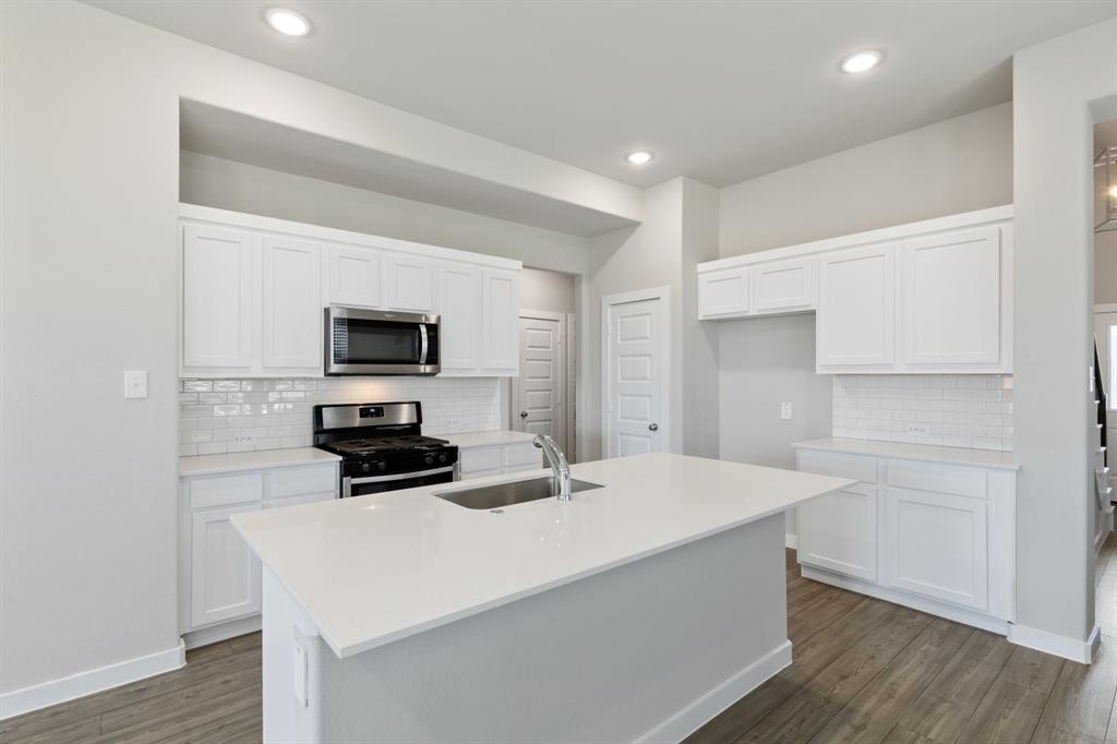 a kitchen with a sink a microwave and cabinets