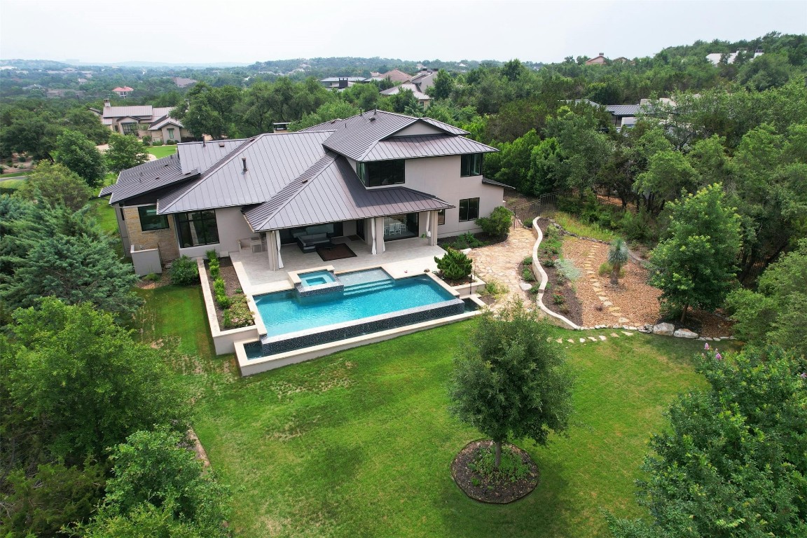 an aerial view of a house with swimming pool garden view and trees